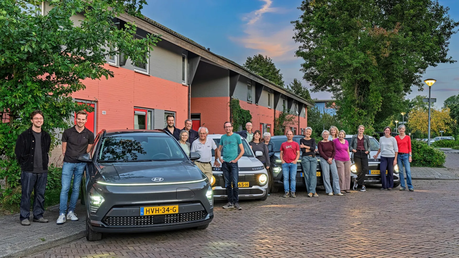Een groep mensen uit Drielanden met hun deelauto's.