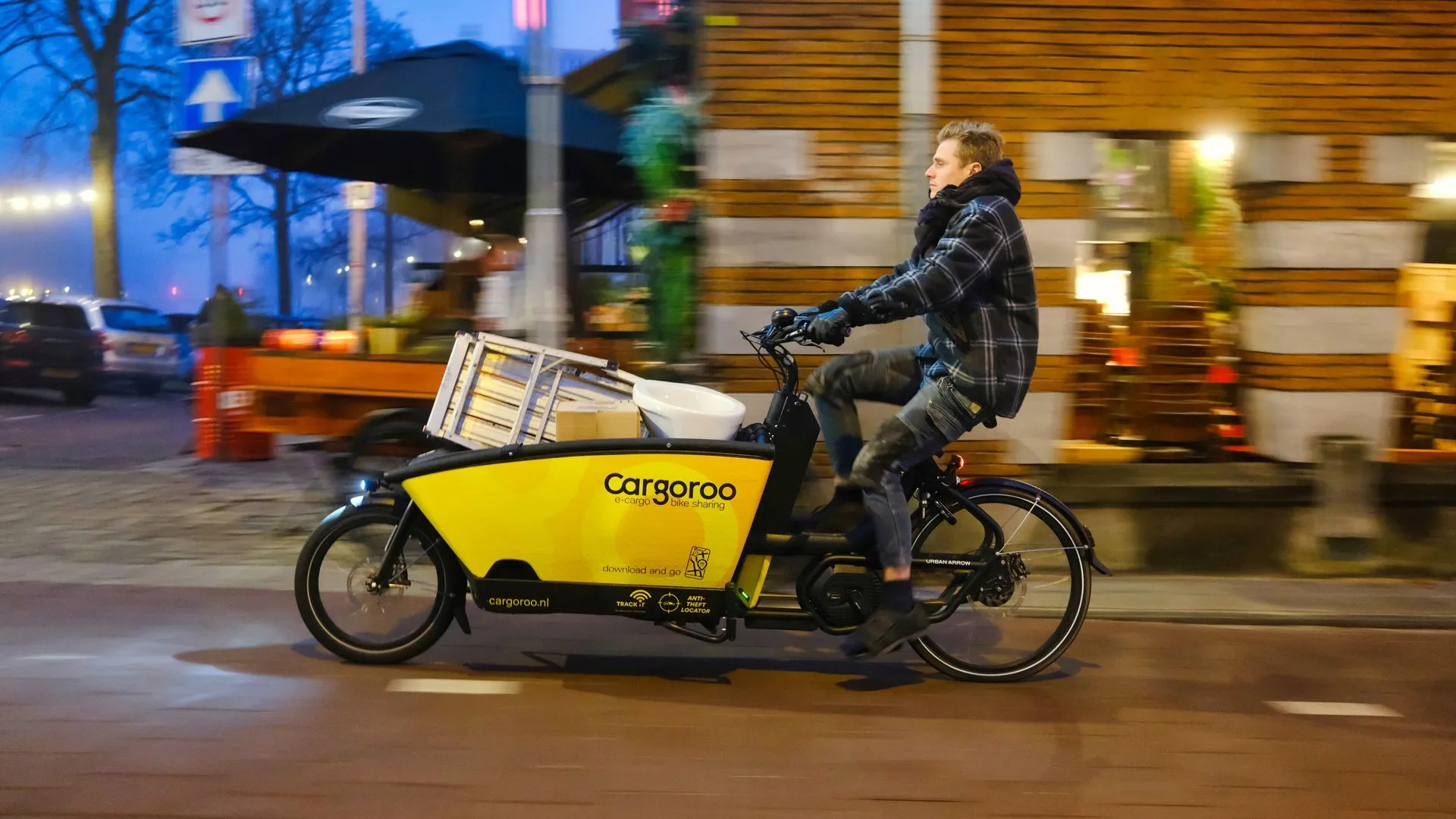 Man fietst met een cargofiets van Cargoroo door de stad.
