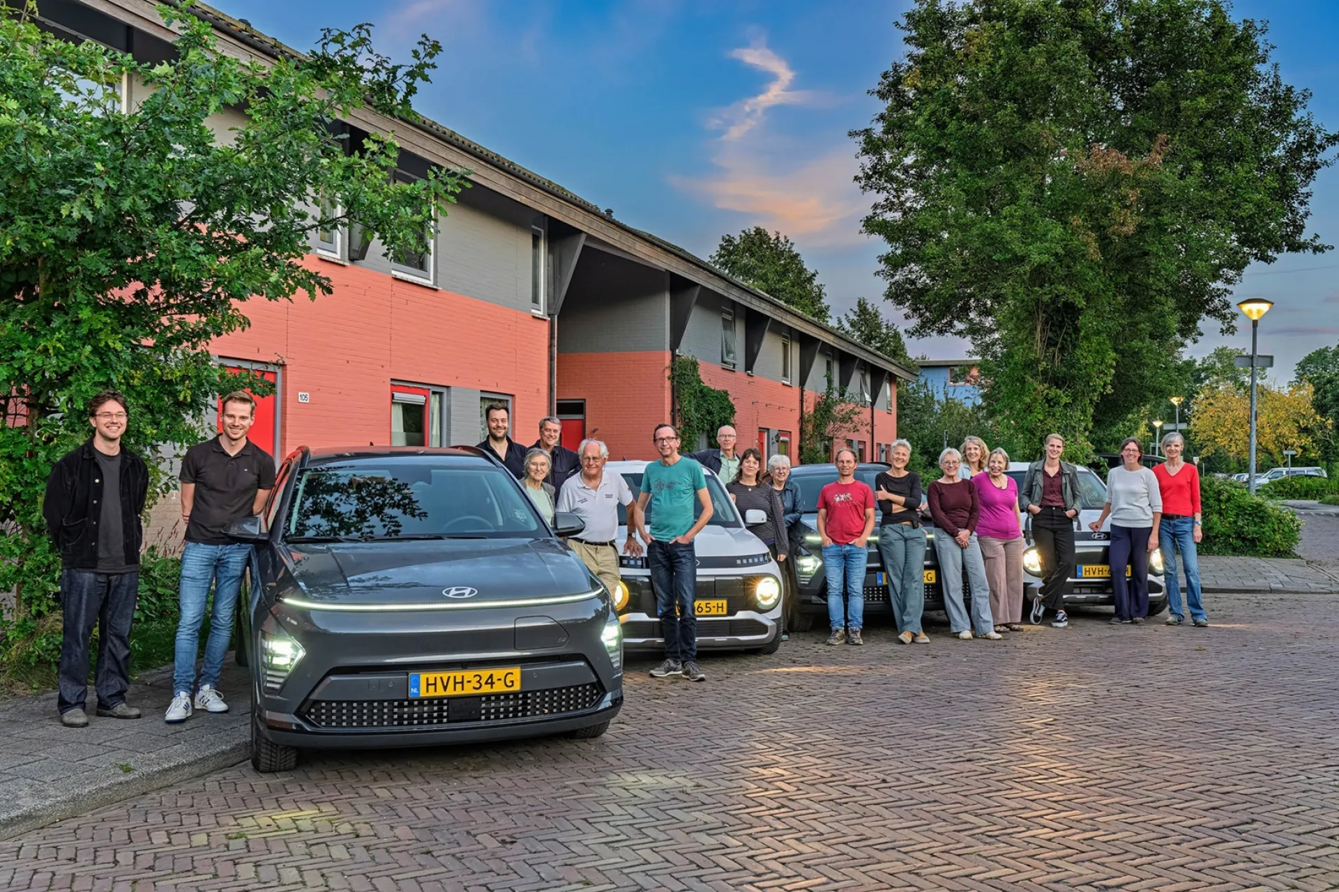 Een groep mensen uit Drielanden met hun deelauto's.