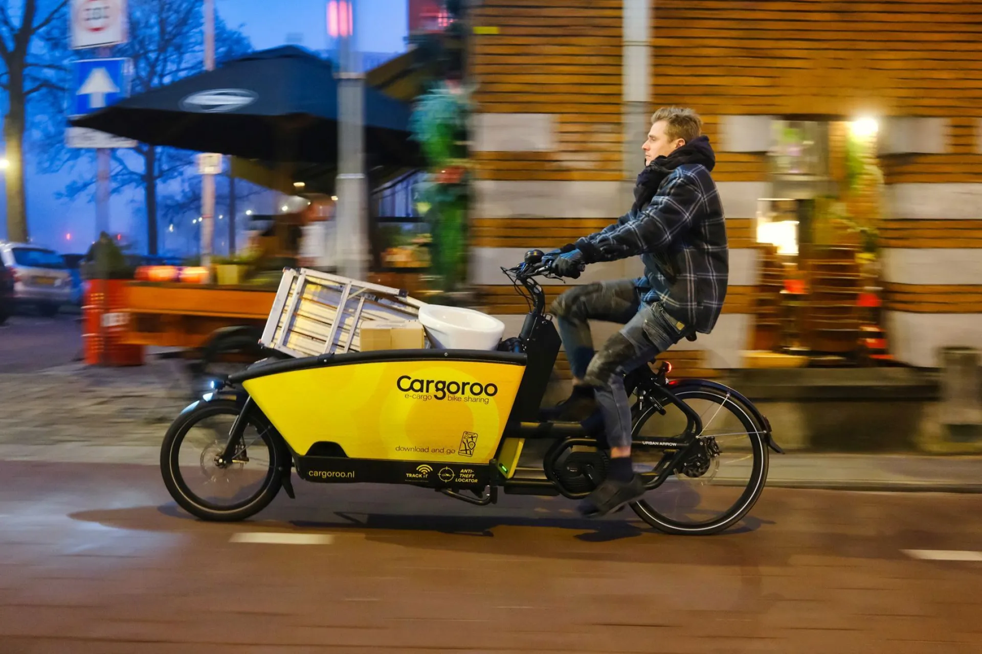Man fietst met een cargofiets van Cargoroo door de stad.